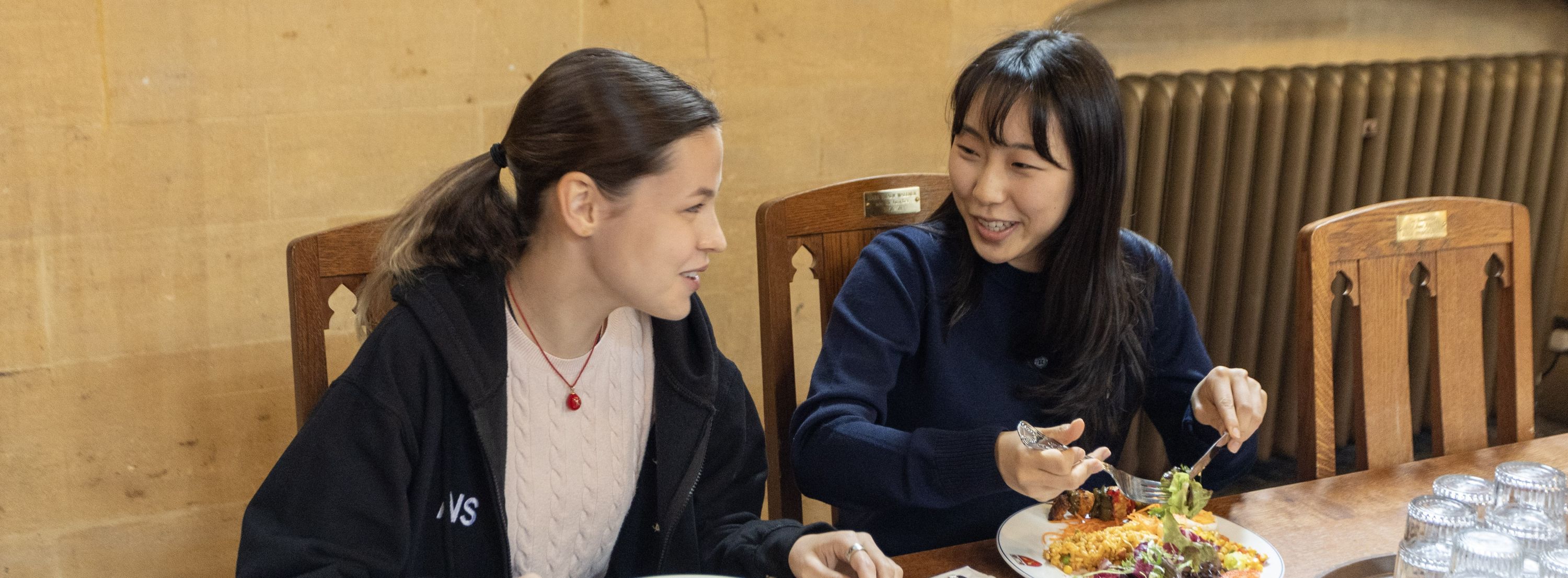 Two students eating in a dining hall