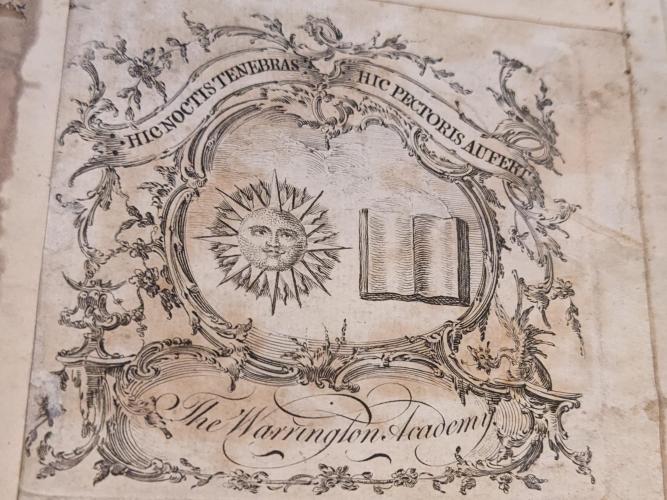 An elaborate bookplate with a sun and book included in a complex design