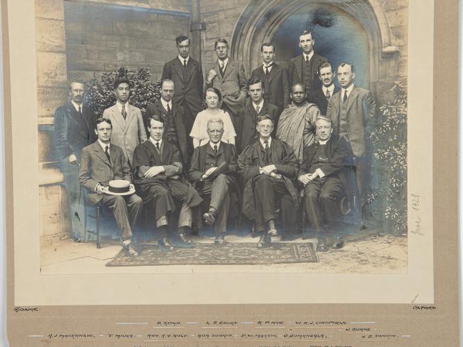 A black and white college photo dated june 1921 showing a group of mostly male students formally posing for the picture. 