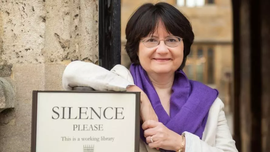 Kate McLoughlin next to library sign with words "Silence Please"