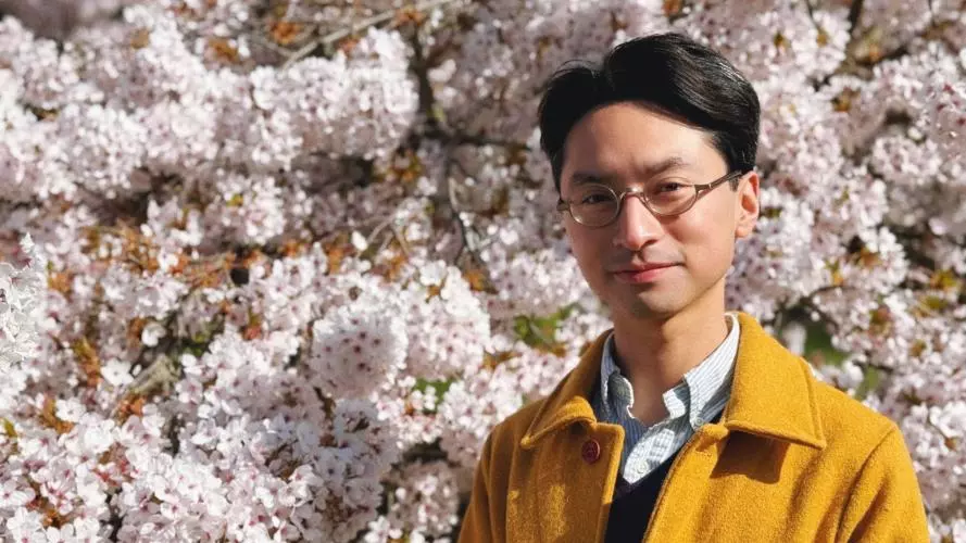 Dr Jordan Miller standing in front of tree with blossom