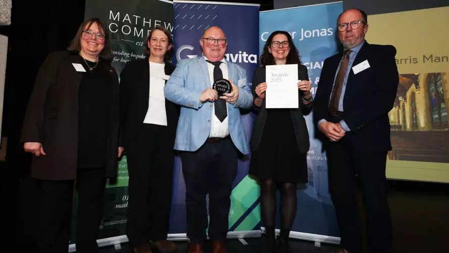Five people in front of an awards display