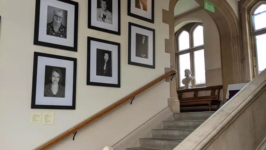 Mounted portraits of the Women Who Made (Harris) Manchester College on the stairs