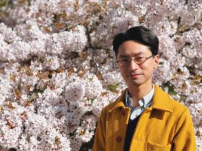 Dr Jordan Miller standing in front of tree with blossom