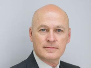 Headshot of a man in a suit with tie