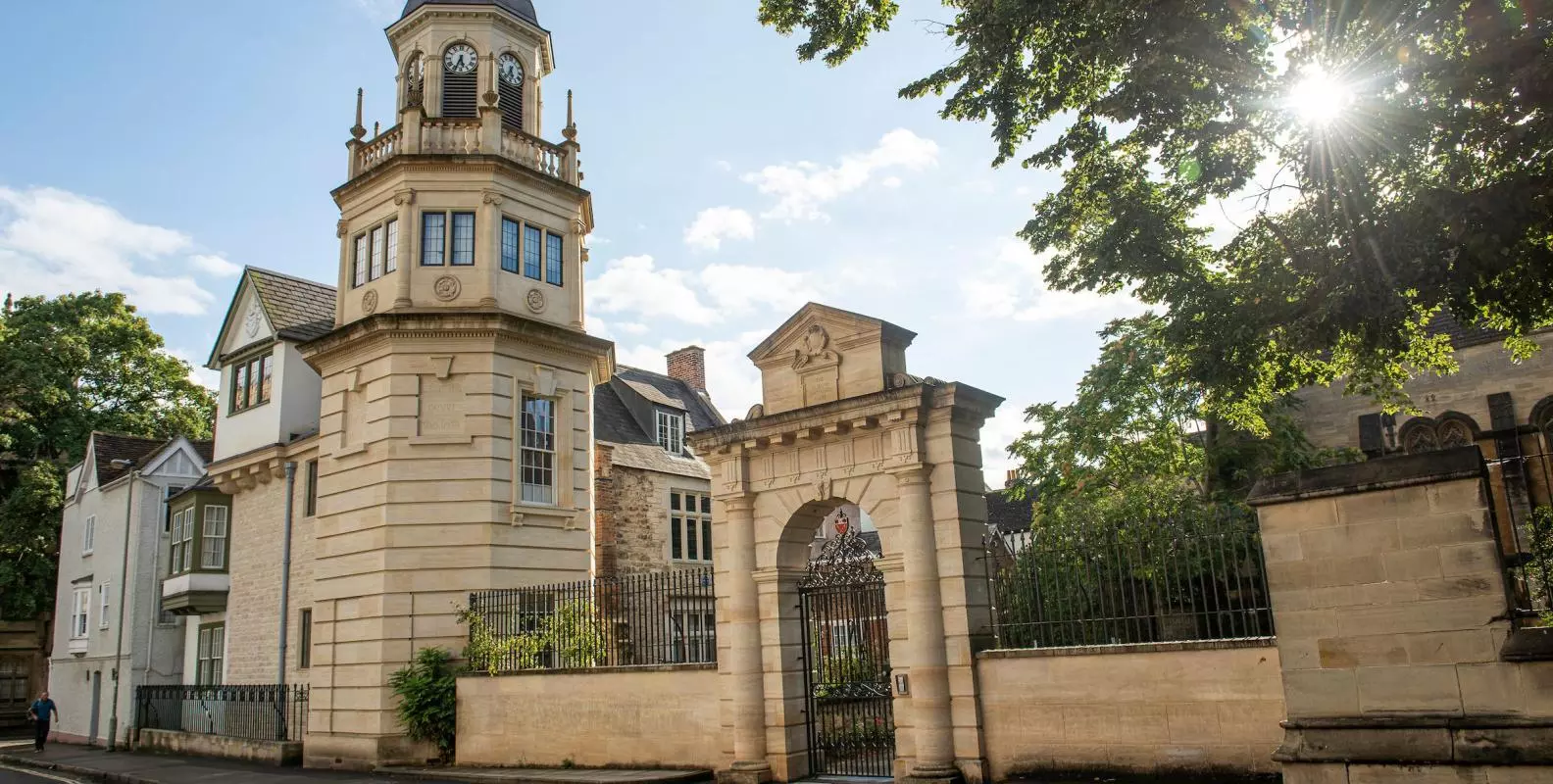 Landscape image portraying a clocktower, entrance to the College and buildings