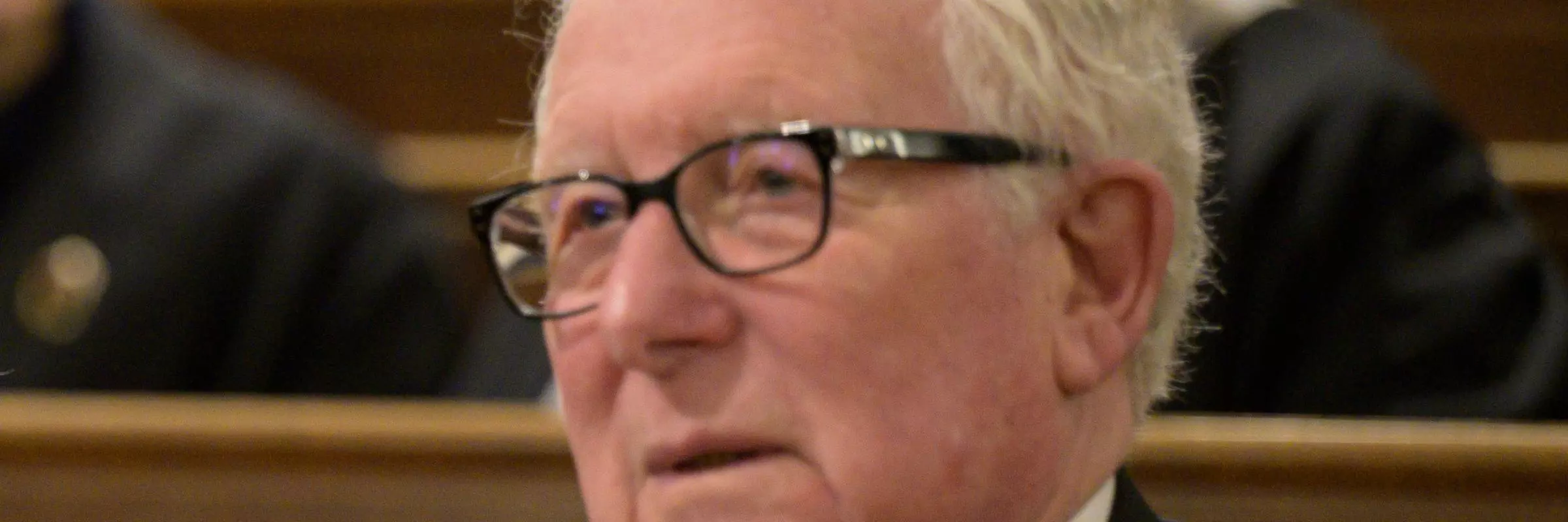 The top half of a man dressed in evening wear sitting down