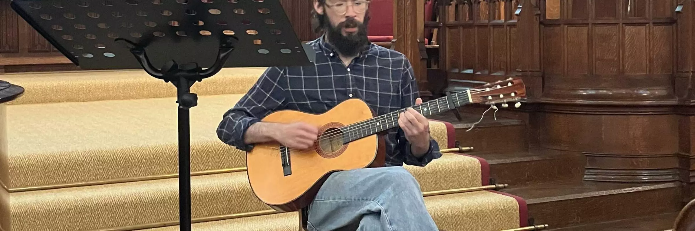 A student plays the guitar in the HMC Chapel