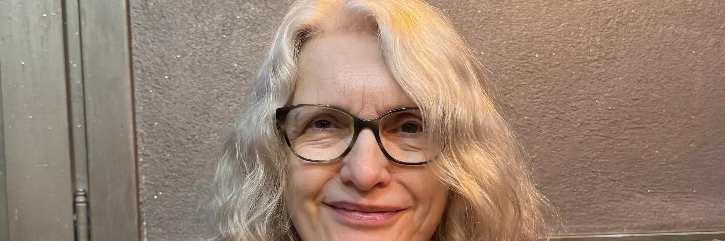 A woman with glasses poses for the camera