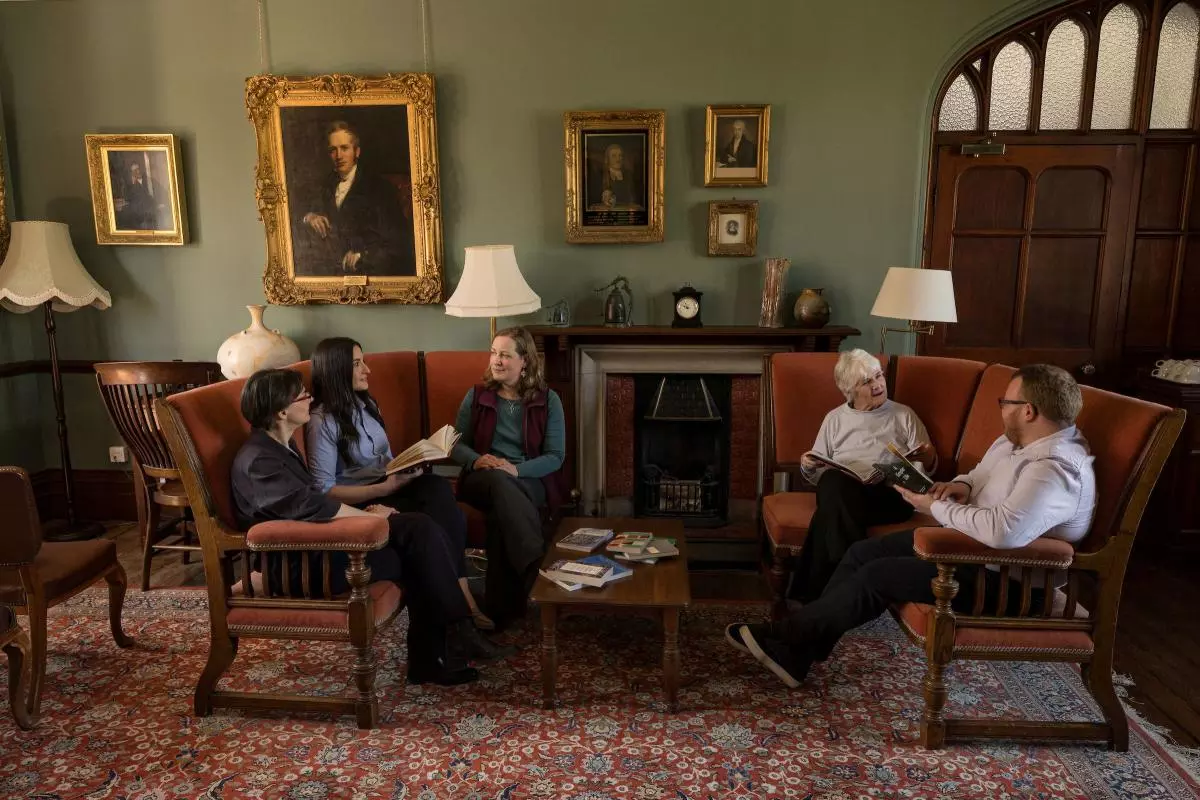 A group of people sitting with books in a study
