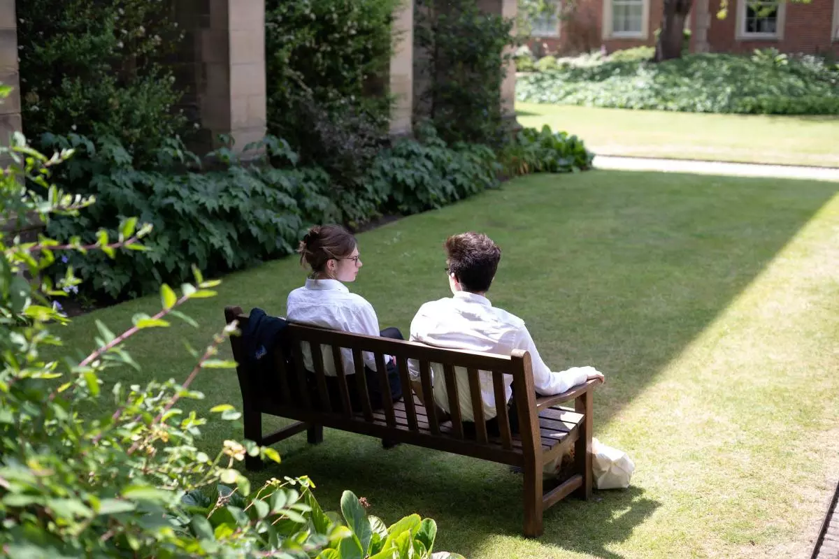 Students on a bench in a college quad