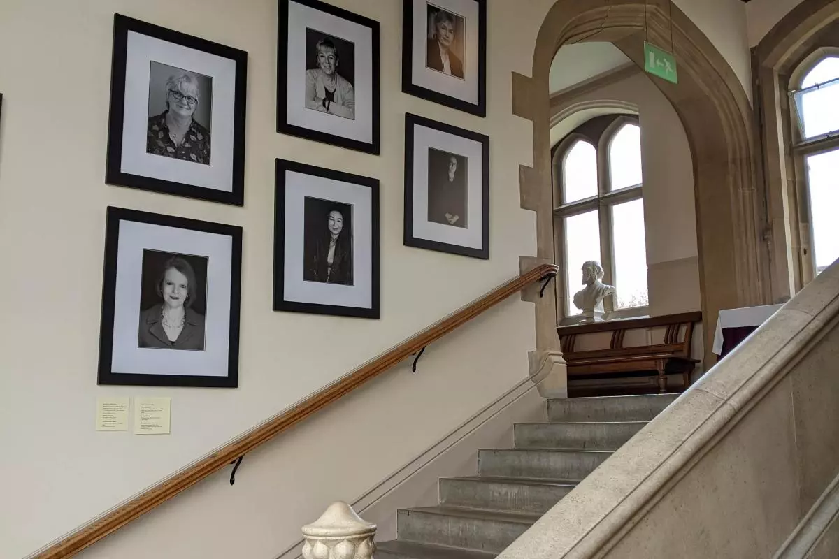 Mounted portraits of the Women Who Made (Harris) Manchester College on the stairs